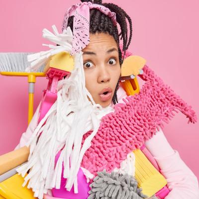 Shocked Stupefied Young Woman Overloaded With Cleaning Tools Has Much Work About House Ready Tidying Up Apartment Poses Against Pink Background Spring Cleaning Housekeeping Concept
